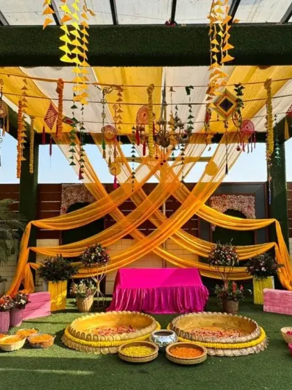 For a fun and flowy Mehendi or Haldi setup, we used bright yellow and orange drapes to create a canopy. The decor is accented with hanging tassels and dreamcatchers, adding a bohemian and festive touch to the celebration.