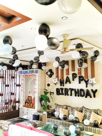 A full view of the 16th birthday home decoration, showing how balloons on the ceiling and a feature wall can effectively decorate a large living space.