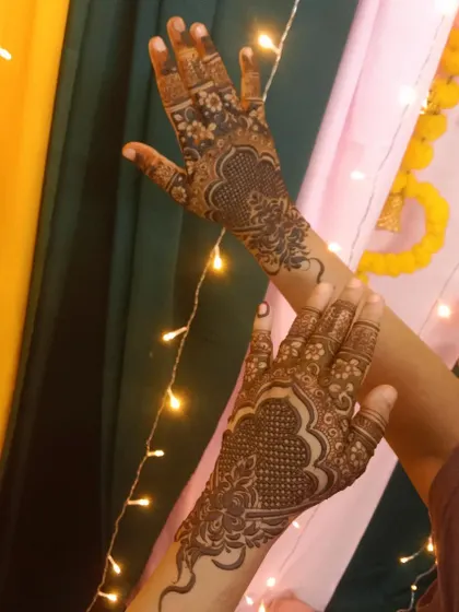 A simple and elegant design on the back of the hands, perfect for a party or guest look. The festive lights in the background add to the celebratory feel.