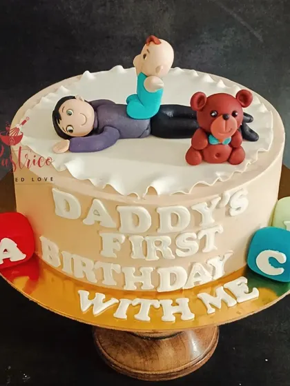 A special cake for a new dad celebrating his first birthday as a father, with a cute topper of him and his baby.