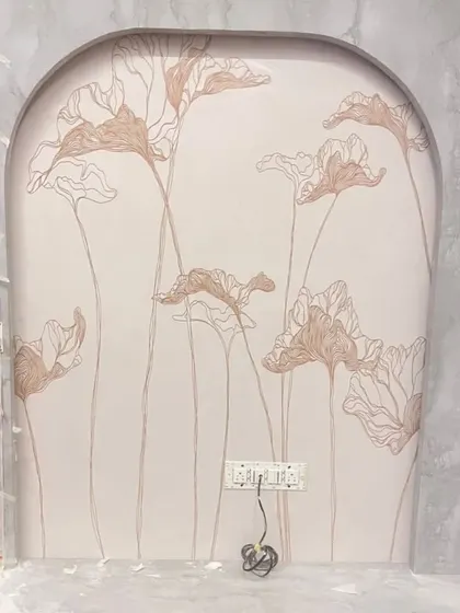 A minimalist line-art floral design being installed in an arched niche, showcasing a simple yet elegant approach to wall decor.