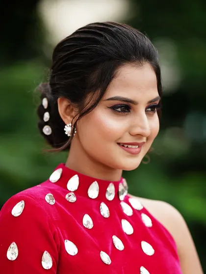 A side profile of Thanvi, showcasing the elegant low bun and flawless makeup I created for her photoshoot.