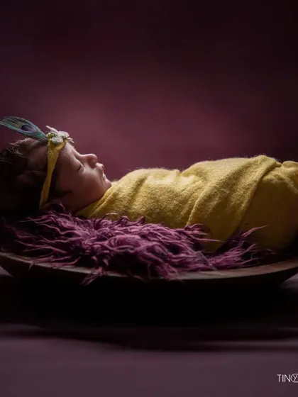 The final image in this series, this portrait captures the quiet beauty of a newborn. The simple props and rich colors make it a stunning piece of art.