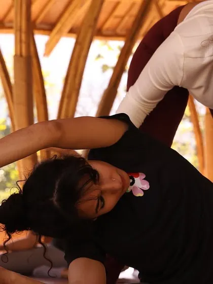 Providing gentle guidance during a seated forward bend. I believe in offering modifications and support so that every practitioner, regardless of their level, can find the benefits of each posture without strain.