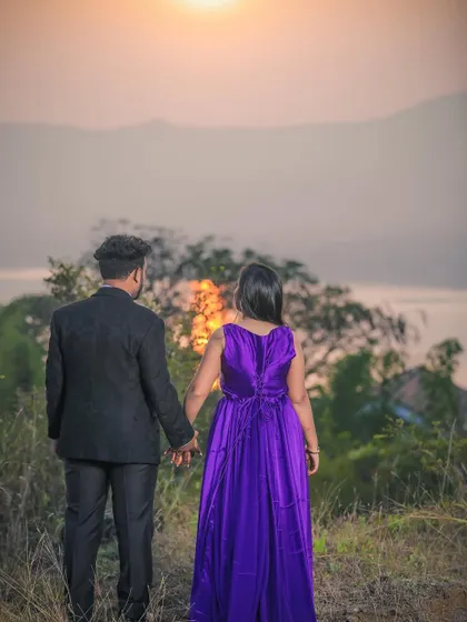 A couple holding hands while watching the sunset over the hills. I seek out beautiful landscapes for pre-wedding shoots that add a sense of wonder and romance.