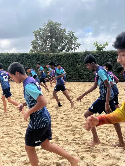 The team running together on the sand, pushing each other to work harder.