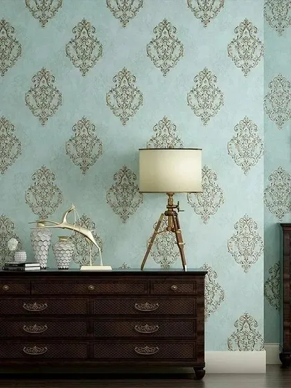 A room mockup with a light blue wallpaper featuring a traditional repeating damask motif.