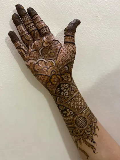 A full-arm design that extends from the fingers to the elbow. It is built with bands of different patterns, including traditional motifs, geometric checks, and delicate vines.