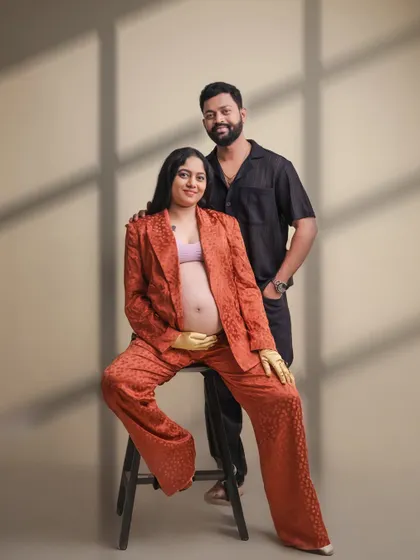 A modern, stylish take on the couple's maternity portrait. The coordinated outfits and confident pose create a chic and contemporary feel.