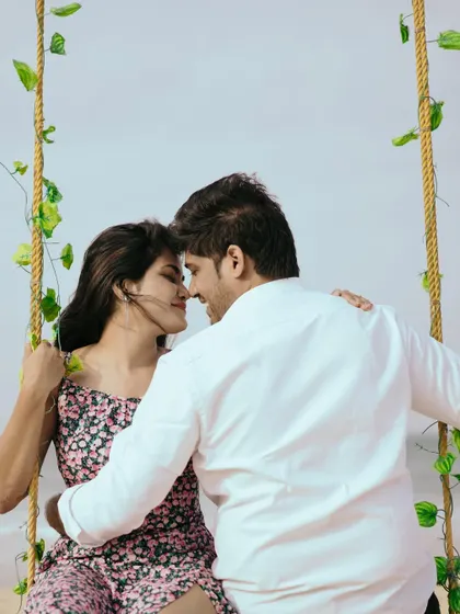 A romantic moment on the swing, just for the two of them. The focus is on their closeness and the beautiful beach setting.
