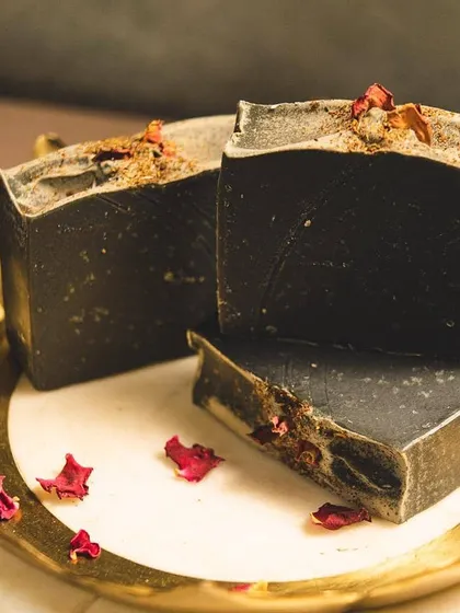 This is my 'Barood' charcoal body bar, made with goat's milk and activated charcoal. It’s a powerful yet gentle cleanser that detoxifies the skin, and the dried rose petals are a little touch of beauty I love to add.