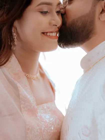 An extreme close-up capturing the groom's gentle kiss on his fiancée's temple. This intimate perspective focuses entirely on their affection and connection.