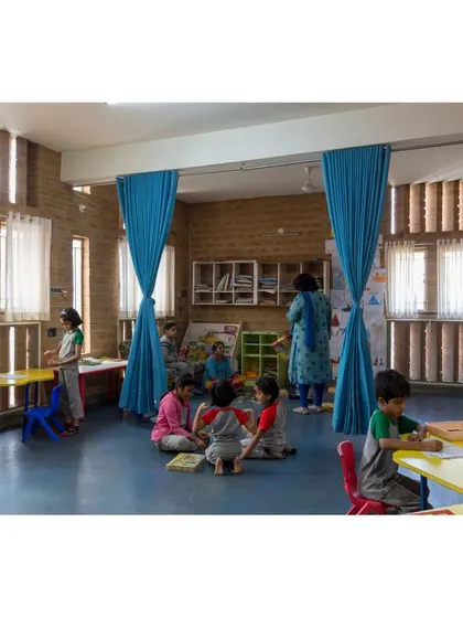 A classroom at Buddhi School where curtains are used to create flexible learning zones. The vertically patterned brickwork allows for diffused natural light while maintaining privacy.