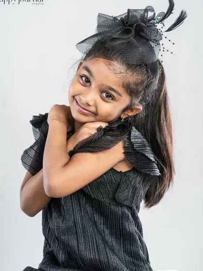A duplicate of image 115, a shy and sweet portrait of a girl in a black dress and fascinator.