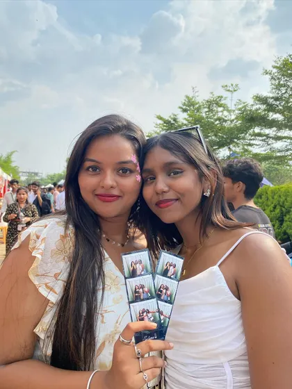 Two friends from Day 1 of Presidency Invincia, happy with their vintage-style photo strips.