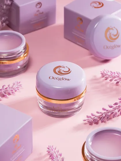 A beautifully styled flatlay of Océeglow products, surrounded by their packaging and lavender sprigs. The soft pink background and harmonious color palette create a gentle, feminine aesthetic. This type of shot is perfect for social media and website banners.