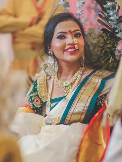 A classic bridal portrait taken during the ceremony, capturing her looking up with a sweet smile, adorned in traditional attire.