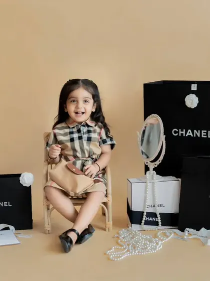 A little fashionista in the making. This fun and glamorous pre-mundan shoot was styled with a high-fashion theme, complete with shopping bags and pearls.