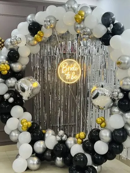For a disco-themed bridal shower, I created this full balloon ring in black, white, and silver. The center features a silver shimmer wall and disco ball balloons, with a 'Bride to be' neon sign to complete the party vibe.