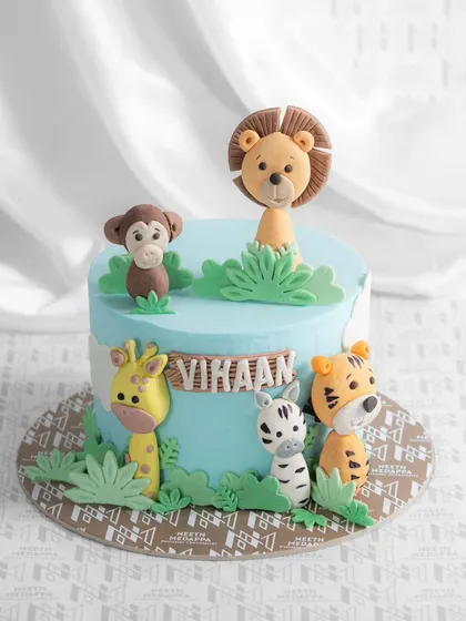 A wild jungle adventure for Vikaan's birthday! This cake is surrounded by adorable, handcrafted fondant animals, including a lion, monkey, giraffe, zebra, and tiger.