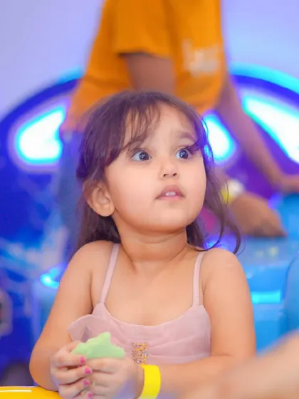 A young girl with a look of wonder on her face as she enjoys the party.