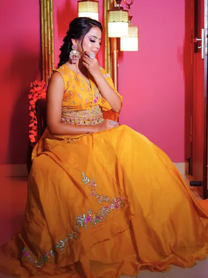 A seated shot of the yellow Haldi lehenga, showing its beautiful drape and fall.
