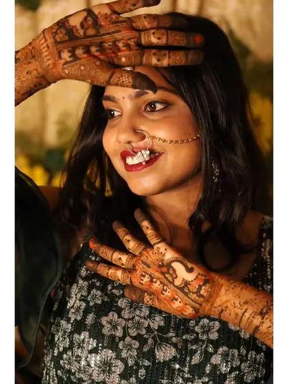 The joy of a bride is infectious. Her hands, decorated with detailed mehendi, are a beautiful part of her wedding celebration.
