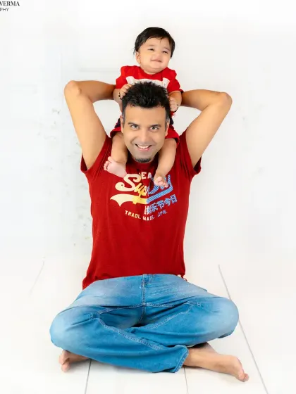 A father gives his son a fun shoulder ride, both of them smiling. This photo is full of energy and captures a classic, playful father-son moment.