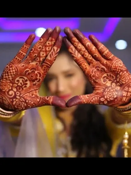 The beauty of a bridal look is in the details. I take great pride in my henna artistry, using organic paste to achieve a deep, long-lasting stain. This close-up shows the intricacy of the traditional design on my bride's hands.