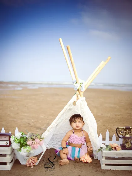 A boho-chic beach setup with a lace teepee. This is a beautiful example of an outdoor session in Mumbai, combining natural beauty with styled props.