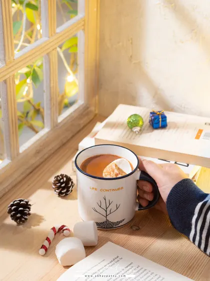 This cozy hot chocolate shot is all about creating a mood. The warm light from the window, the marshmallows, and the books create a perfect winter evening scene.