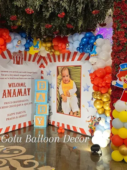 Another view of the carnival party photo corner, showcasing the vibrant red, blue, and yellow balloon columns and clown prop.