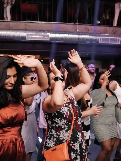 A duplicate of the women dancing in sync. It's a great shot of the crowd's shared energy.
