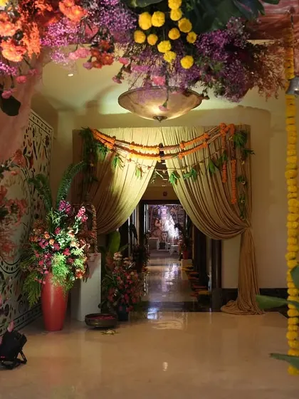 Looking through the traditional floral archway, you can see the path ahead draped in marigold garlands and curtains, building layers of festive beauty.