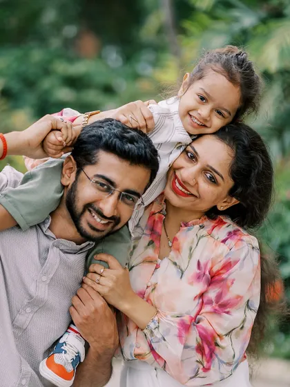 A family portrait with the son on his father's shoulders. A classic pose that is always full of joy.