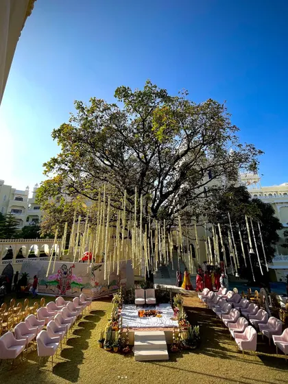 A wide view of the wedding ceremony setup at The Everest Hill Resort, with the mandap perfectly framed by the ancient tree and the palace facade in the background.
