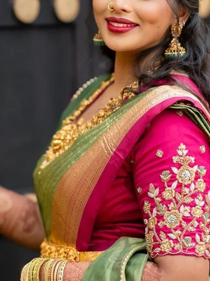 A closer look at the beautiful hand embroidery on this bride's pink blouse, featuring floral motifs in gold thread that perfectly complement her green Kanjeevaram saree.