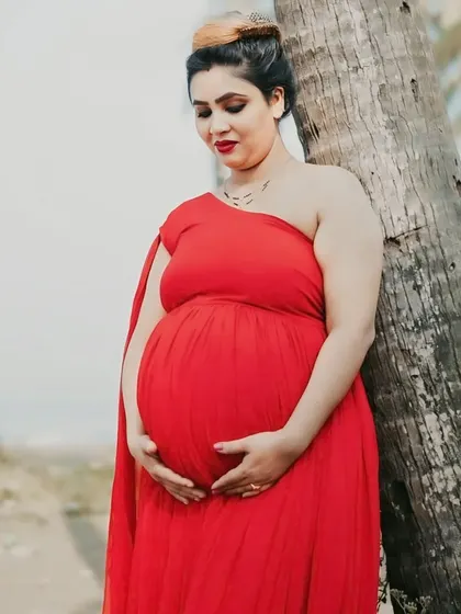 A peaceful portrait of a mom-to-be. The one-shoulder design of this red georgette gown is both stylish and comfortable for a maternity session.