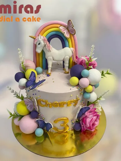 This unicorn cake is a burst of magic and color. It features a sculpted unicorn, a vibrant rainbow, and is adorned with butterflies, flowers, and colorful spheres for a truly enchanting third birthday.