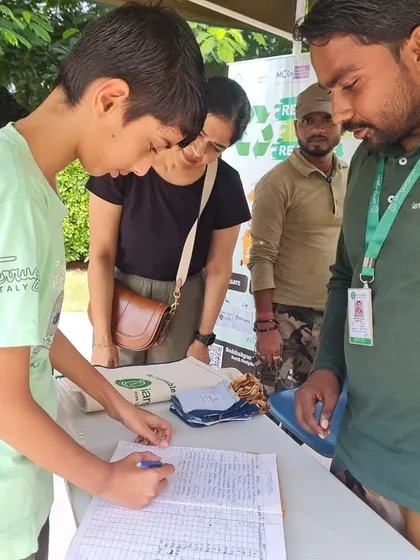 A student signs the register at the waste collection drive, taking ownership of his contribution to a cleaner environment.