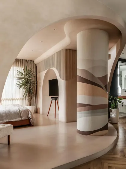 The master suite was designed as a single, fluid space. An obstacle, a lone column, was transformed into a statement piece with custom wallpaper, anchoring the room's design.