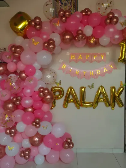 The same pink and rose gold setup, showing the foil name and number balloons.