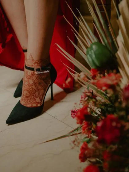 The henna stain on feet can be just as stunning. This artistic shot shows how beautifully a simple foot design pairs with elegant heels, highlighting the rich, dark color.