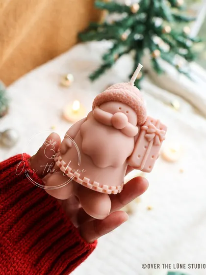 A cute, hand-painted Santa Claus candle from my Christmas collection. He's holding a little gift and is ready to spread some holiday cheer.