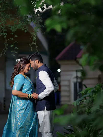 A quiet, intimate portrait of a couple standing forehead to forehead under natural foliage. This kind of shot is perfect for capturing the peaceful, loving connection between two people.