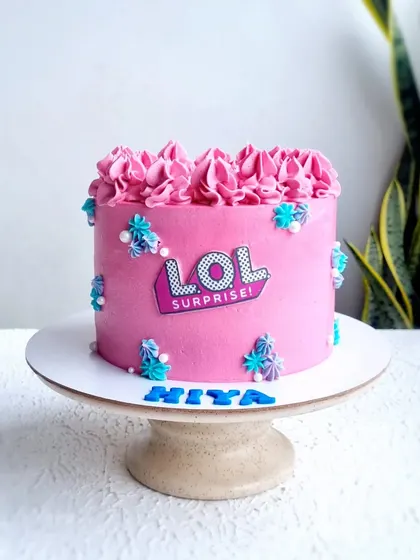 A full view of the pink LOL Surprise buttercream cake.