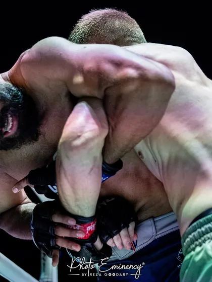 Fighting for position against the cage. This image shows the grueling clinch work and physical strength our fighters develop to control the fight wherever it goes.