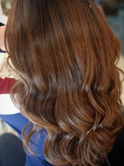 A close-up of the warm caramel hair color, showing the beautiful shine and healthy condition of the hair after our coloring service.