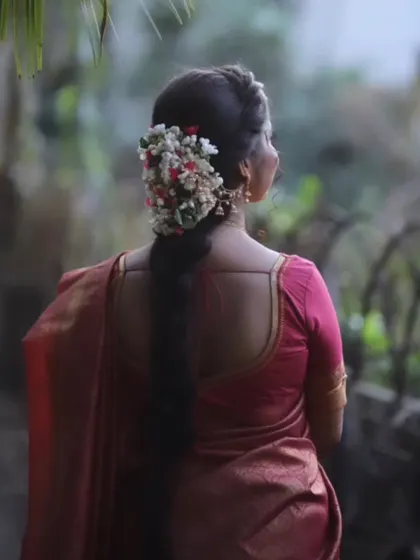 The back view of a bride, highlighting the beautiful gajra (floral arrangement) in her hair, a signature element of the South Indian bridal look.