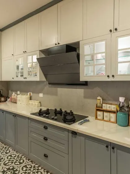 The combination of white and powder grey cabinets with classic black knobs gives this kitchen a timeless, elegant look.